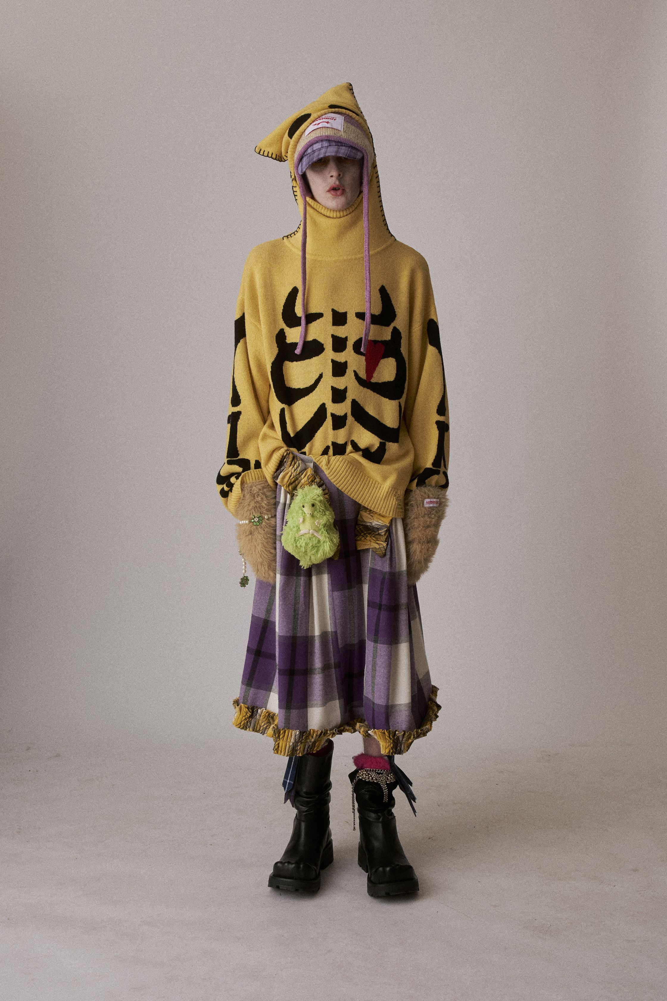 Charles Jeffrey Loverboy 2026秋冬继续以“童话式反叛”挑战性别与规范，苏格兰格纹、手工针织、玩偶配饰与夸张头饰构成近乎戏剧化的造型语言。服装在稚拙与暗黑之间游走，像一场带有朋克精神的成人童话，表达边缘身份的自我认同与情绪释放。这不是可被轻易驯化的时装，而是一种对主流秩序的持续挑衅-顽石频道趋势研究
